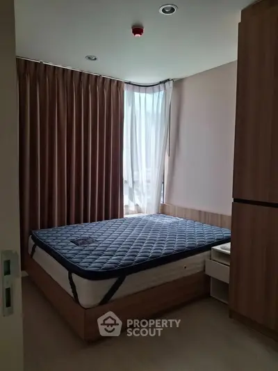 Cozy bedroom with natural light and modern furnishings, ideal for relaxation.