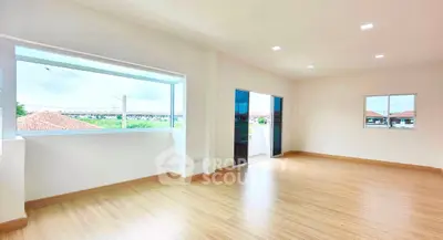 Spacious bright room with wooden flooring and large windows offering scenic views.