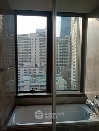 Luxurious bathroom with city view from large window, featuring modern bathtub and sleek design.