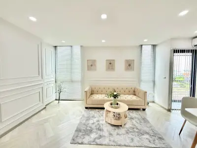 Elegant living room with modern decor and natural light, featuring a plush sofa and stylish coffee table.