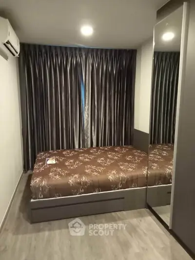 Cozy bedroom with elegant curtains and mirrored wardrobe in modern apartment.