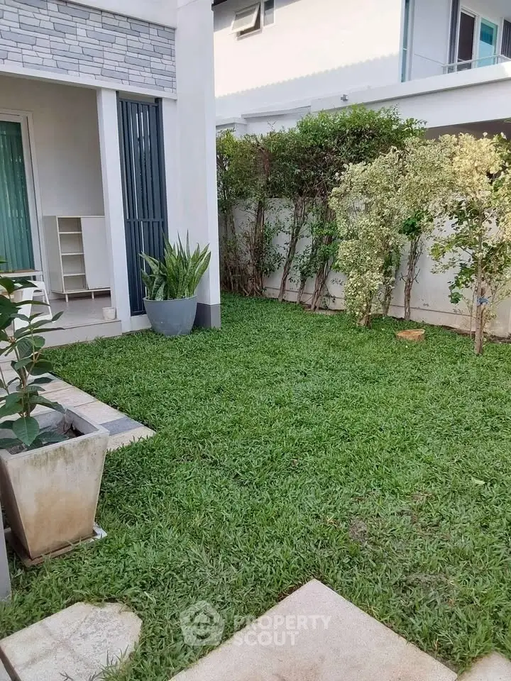 Charming garden area with lush greenery and modern exterior design, perfect for relaxation and outdoor activities.