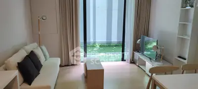 Modern living room with natural light, cozy sofa, and garden view, perfect for relaxation and entertainment.