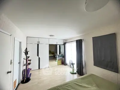 Spacious bedroom with mirrored wardrobe and natural light