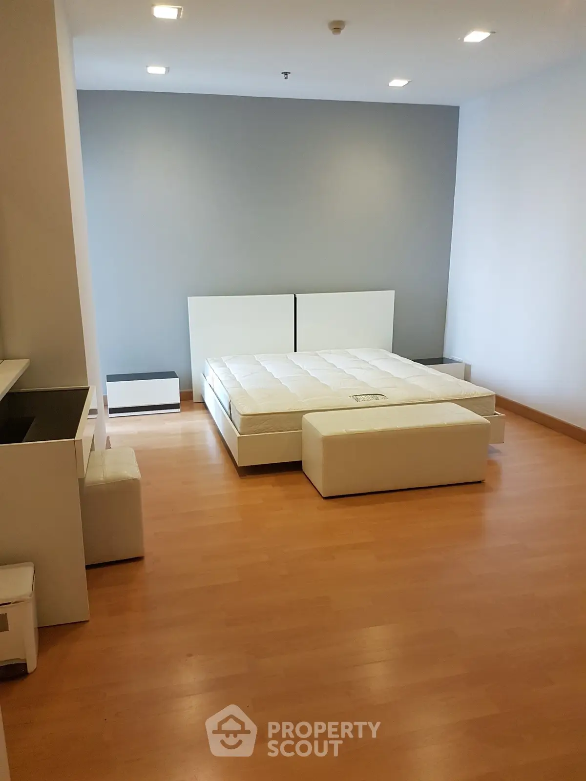 Spacious modern bedroom with minimalist design and wooden flooring