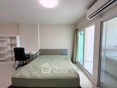 Spacious bedroom with balcony access and modern furnishings in a bright apartment.