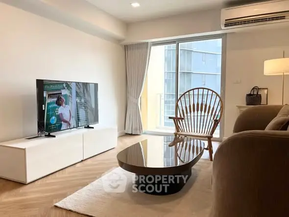 Modern living room with stylish furniture and large window offering natural light.