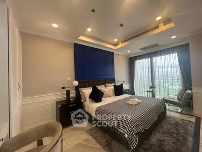 Luxurious bedroom with modern decor and large window offering stunning views.
