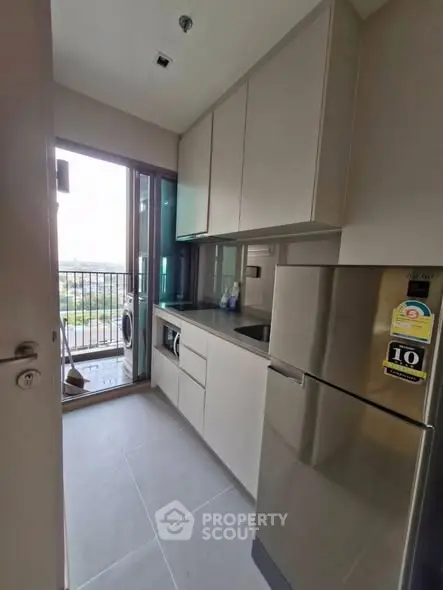 Modern kitchen with sleek cabinets and balcony view