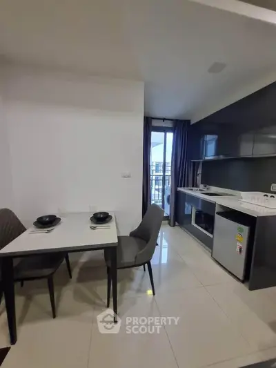 Modern kitchen with dining area and balcony view in stylish apartment