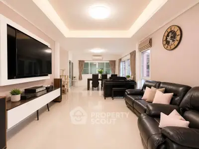 Spacious modern living room with leather sofas and large TV, perfect for family gatherings.