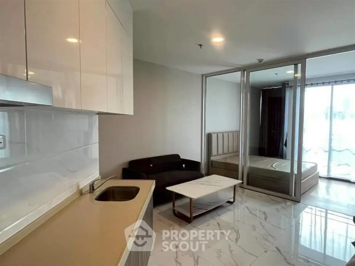 Modern studio apartment with sleek kitchen and cozy living area