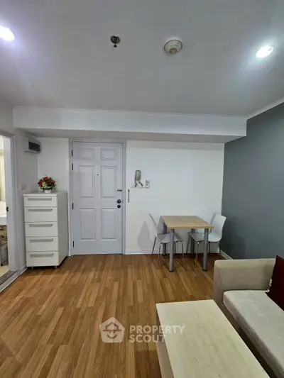 Modern living room with wooden flooring and minimalist furniture in a cozy apartment.
