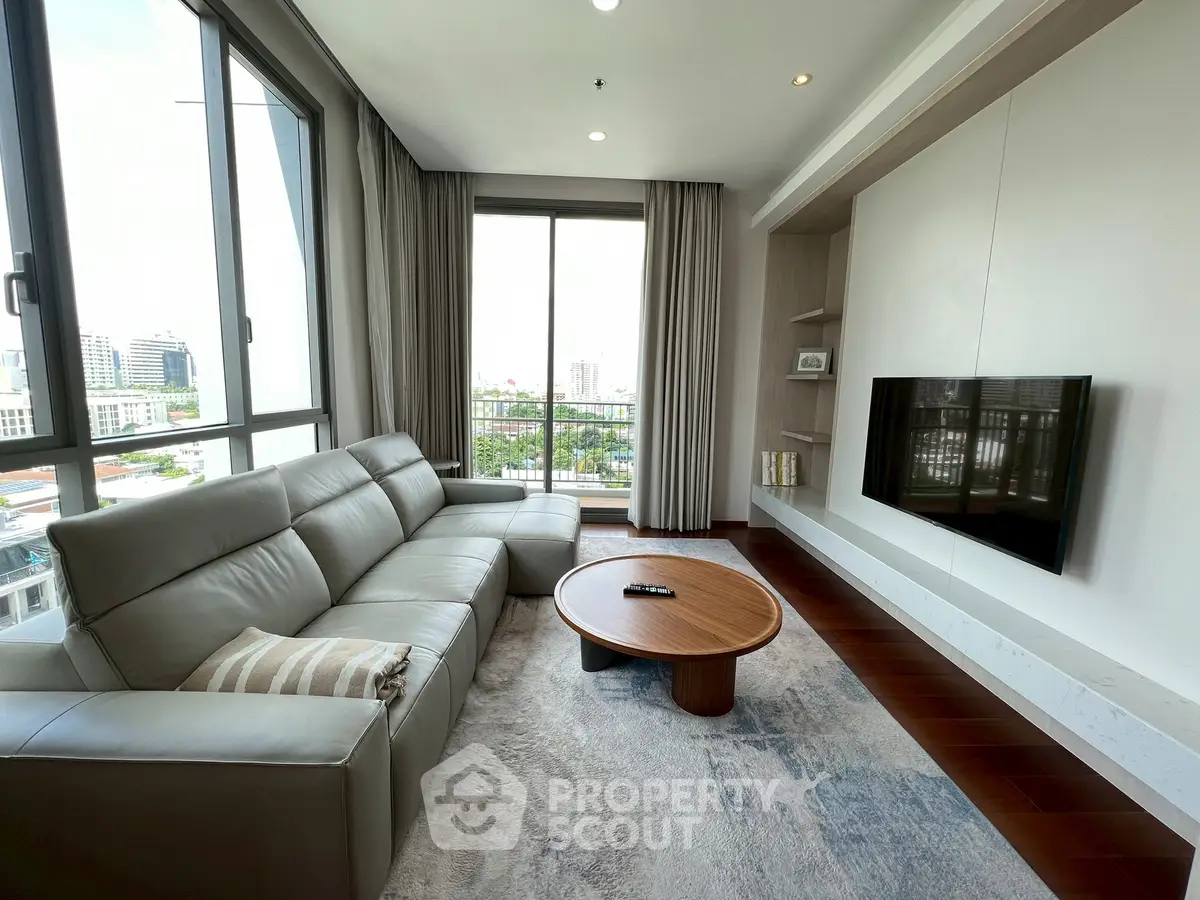 Modern living room with large windows and stylish furniture, offering a bright and inviting atmosphere.