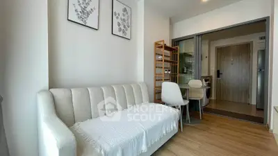 Modern living room with cozy sofa and dining area in open layout apartment.