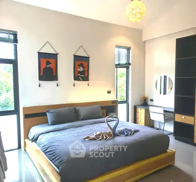 Modern bedroom with stylish decor and natural light, featuring a cozy bed and elegant workspace.