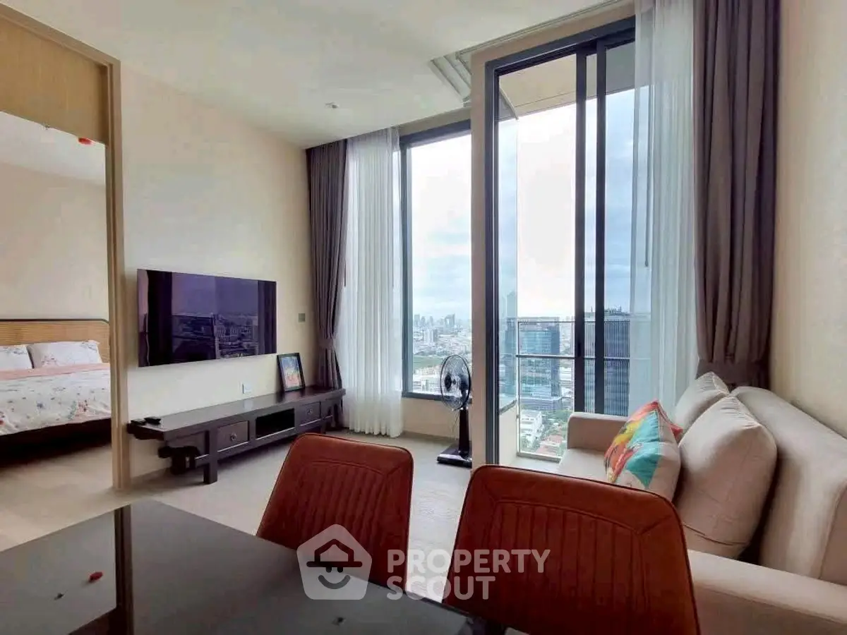 Modern living room with large windows offering stunning city views, adjacent to a cozy bedroom.