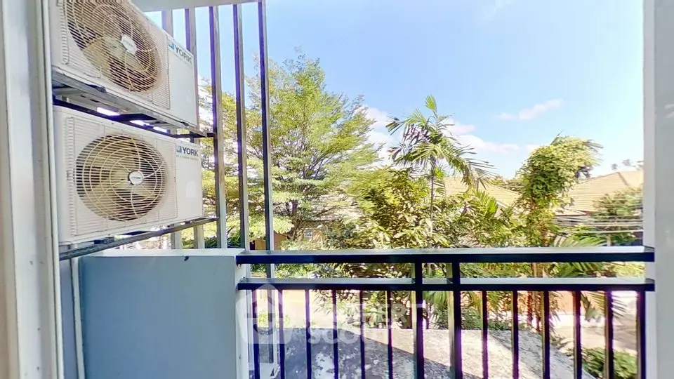 Charming balcony with lush green view and air conditioning units.