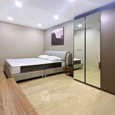 Modern bedroom with sleek design, mirrored wardrobe, and cozy lighting for a comfortable living experience.