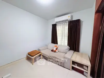 Cozy living room with modern sofa and air conditioning, perfect for relaxation.
