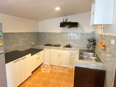 Modern kitchen with gas stove and sleek countertops in a stylish home.
