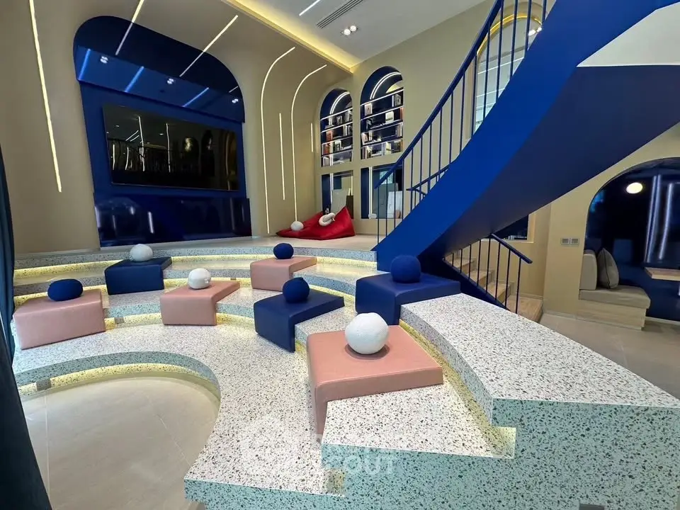 Modern living room with unique tiered seating and vibrant blue accents