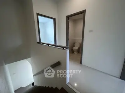 Modern interior with staircase and bathroom access, showcasing sleek design and functionality.