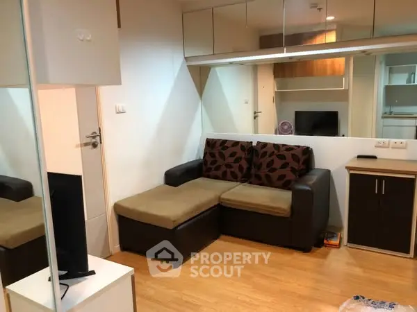 Modern living room with cozy sofa and mirrored wall enhancing space