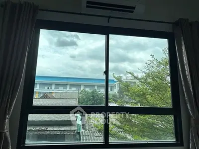 Scenic view from window with lush greenery and urban landscape