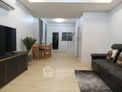 Spacious modern living room with sleek furniture and dining area, perfect for family gatherings.