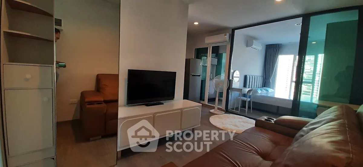 Modern apartment interior with cozy living room and bedroom, featuring sleek furniture and natural light.