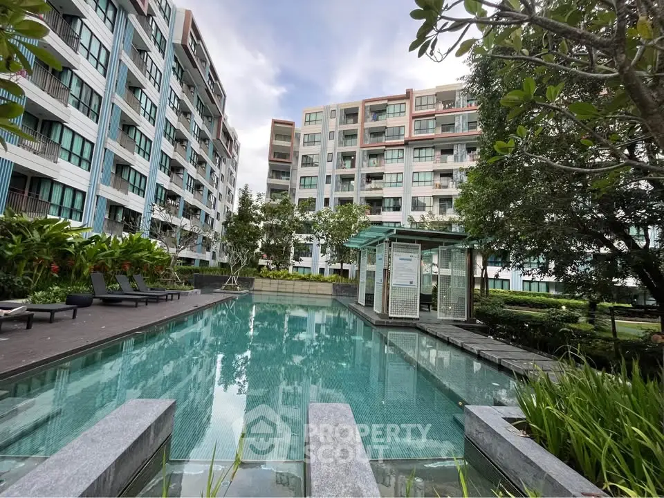Modern apartment complex with a luxurious swimming pool and lush greenery