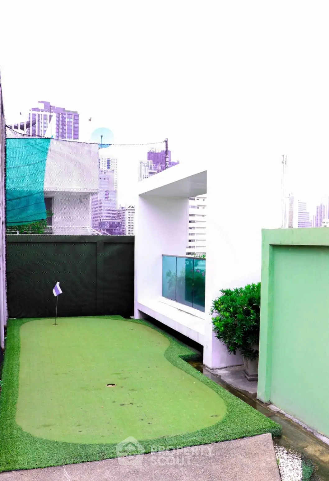 Rooftop mini-golf area with city skyline view, perfect for leisure and relaxation.