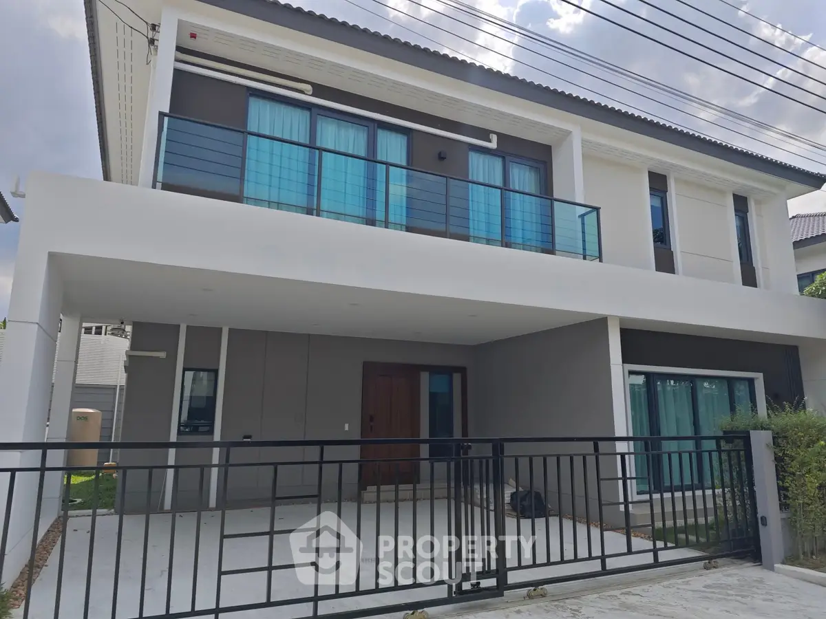 Modern two-story house with sleek balcony and spacious driveway