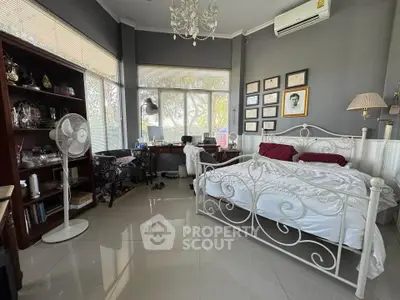 Spacious bedroom with elegant decor and large windows offering natural light.