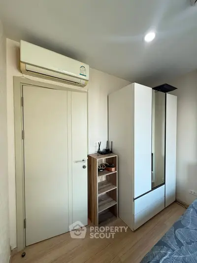 Modern bedroom with sleek wardrobe and air conditioning unit, perfect for comfortable living.