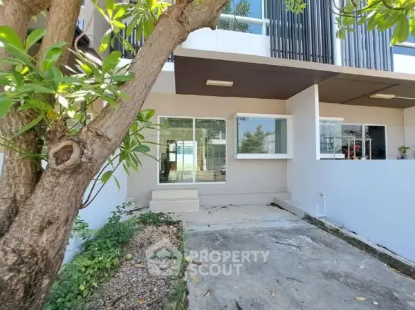 Modern townhouse exterior with large windows and garden view