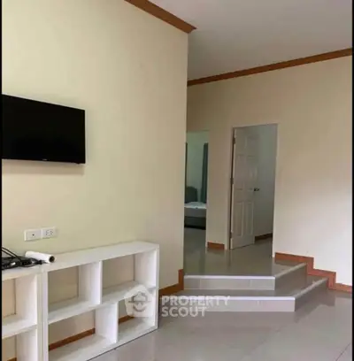 Modern living room with wall-mounted TV and open shelving unit