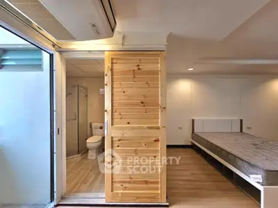 Modern studio apartment with wooden sliding door and cozy bedroom