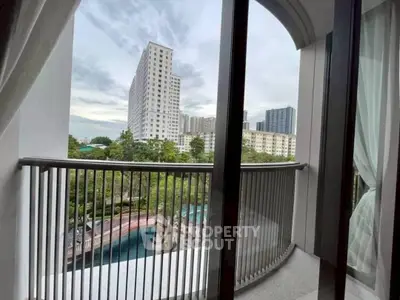 Stunning balcony view with modern high-rise buildings and lush greenery.
