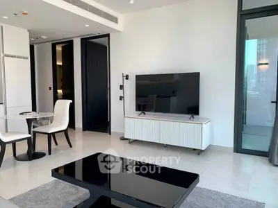 Modern living room with sleek furniture and large TV in a stylish apartment.