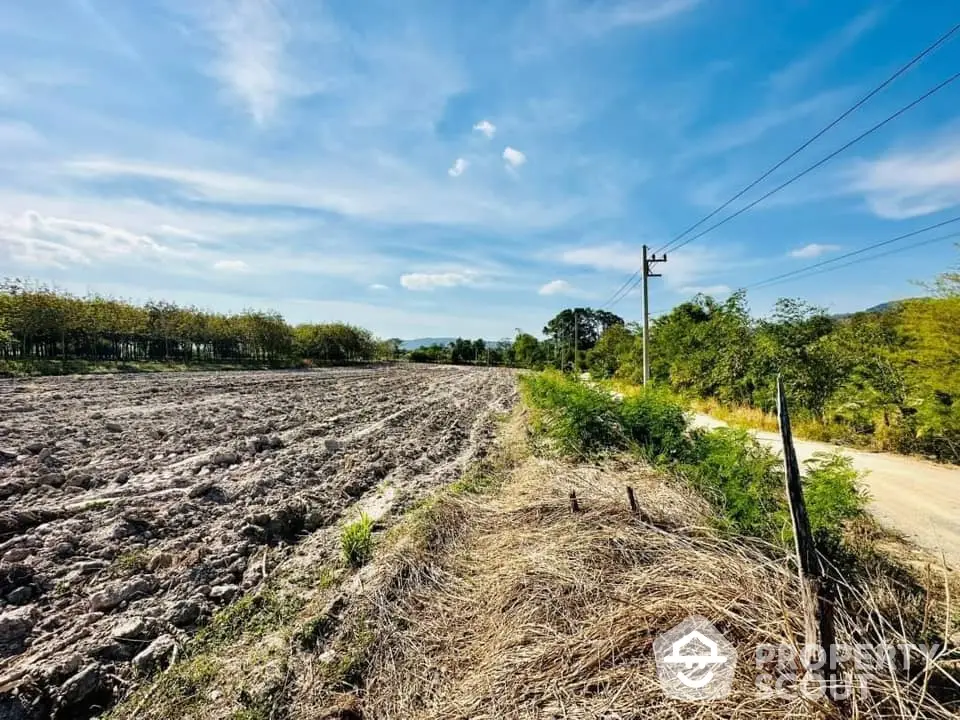 Expansive fertile farmland under a clear blue sky, perfect for agricultural development or a rural homestead.