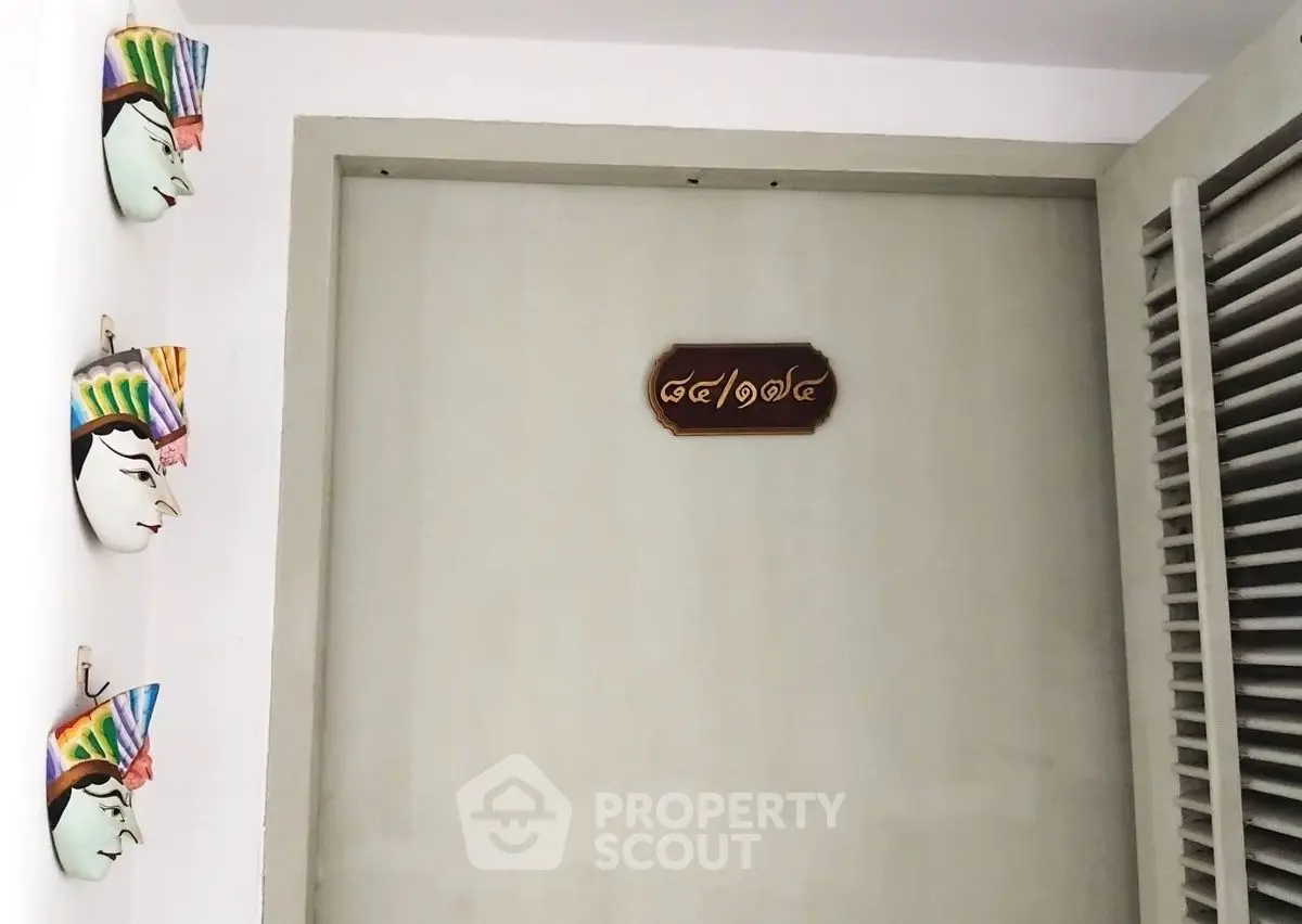 Unique entrance with artistic wall decor and traditional sign