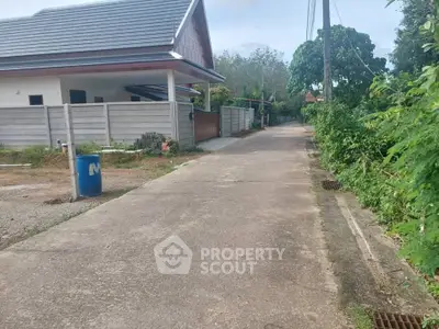 Charming suburban house with spacious driveway and lush greenery, perfect for tranquil living.