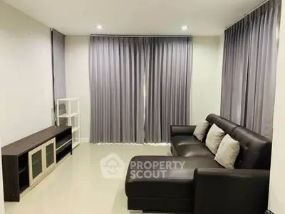 Modern living room with sleek furniture and elegant curtains in a cozy apartment.