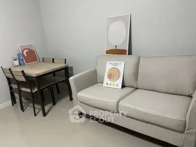 Modern living room with cozy grey sofa and stylish dining table, perfect for small apartments.