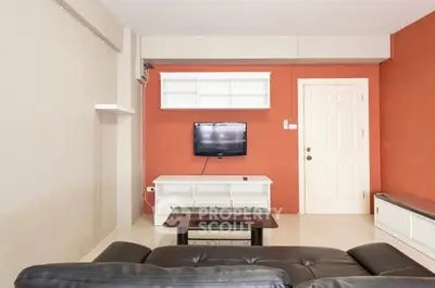 Modern living room with sleek furniture and wall-mounted TV, perfect for relaxation and entertainment.
