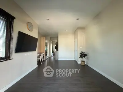 Spacious modern living room with wall-mounted TV and stylish decor