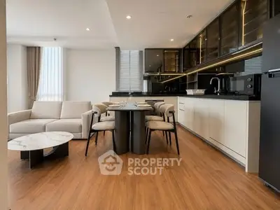 Modern open-layout kitchen and living room with sleek design and wooden flooring.