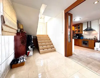 Spacious open-plan kitchen with modern appliances and adjacent staircase in a bright home interior.